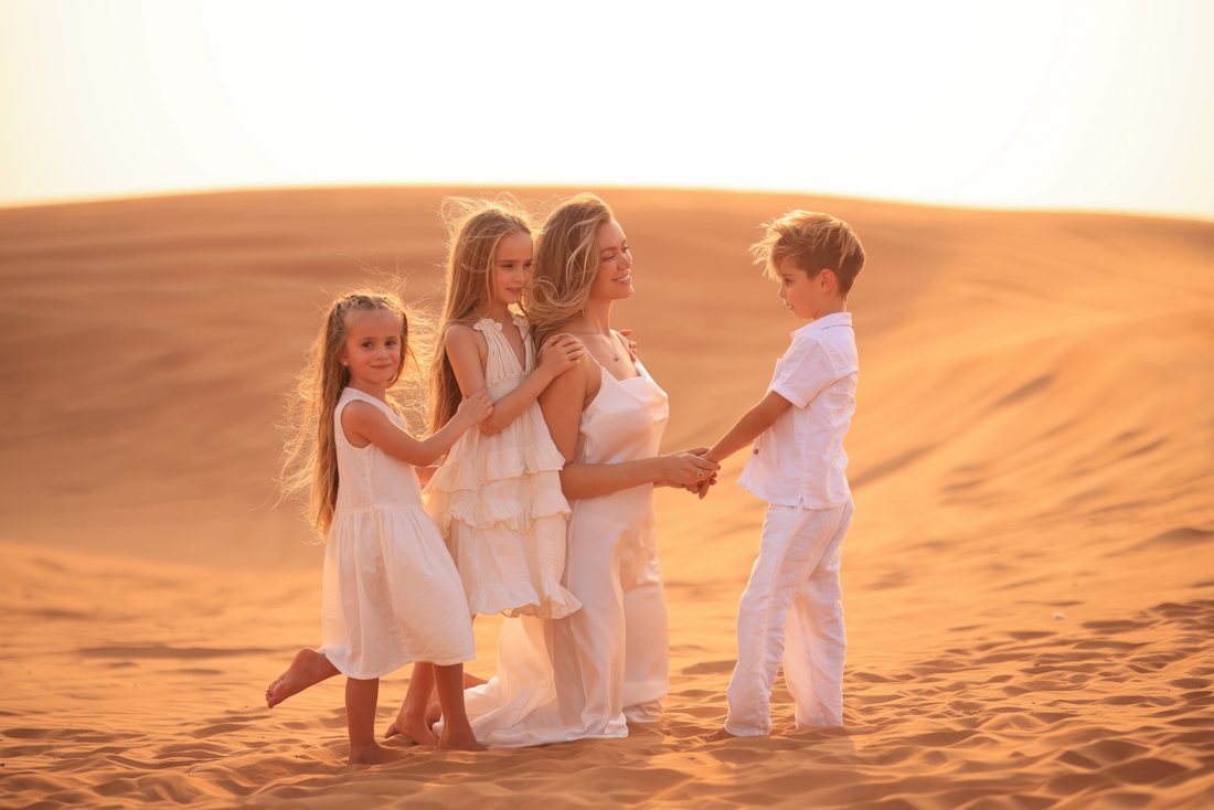 Mother with her three children in white on the dunes at sunset — family photographer Dubai